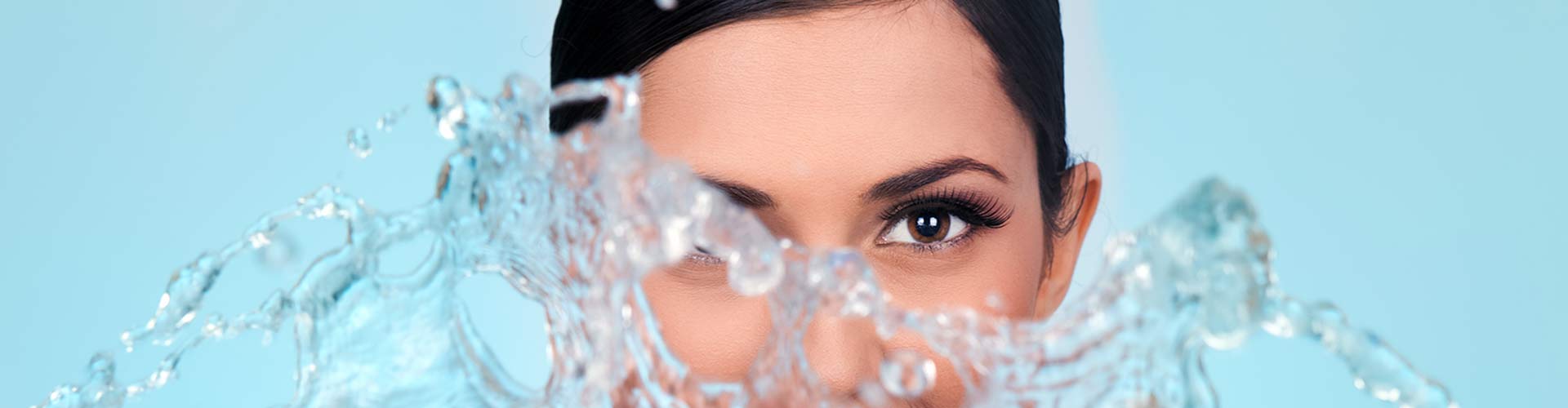 Woman with water splashing on her eyes